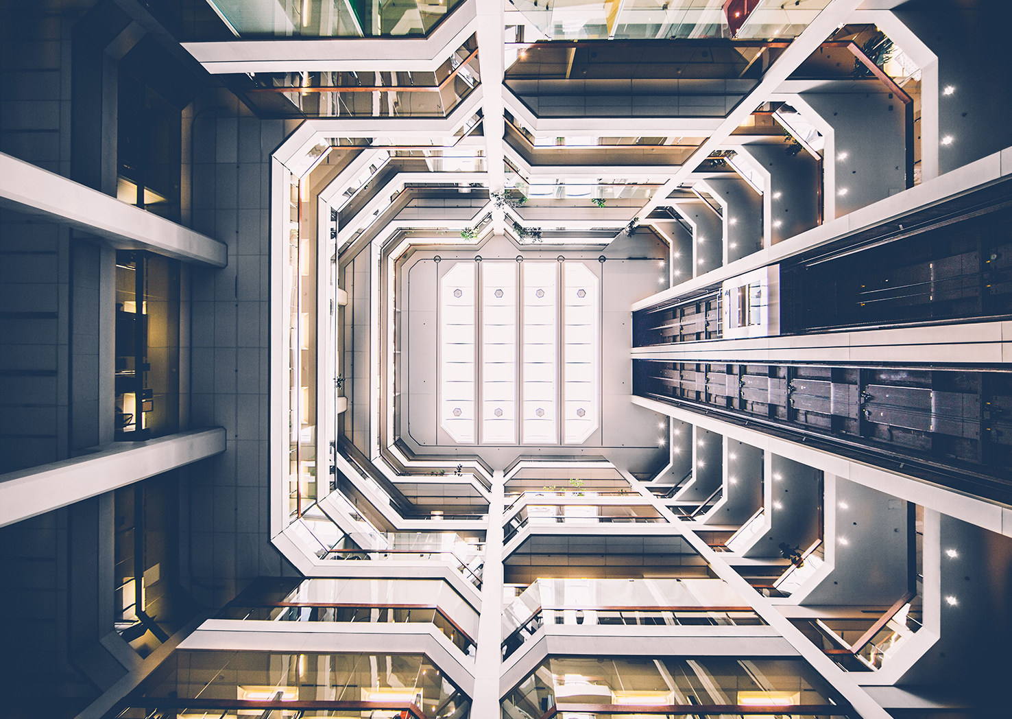 Glass elevators and escalators inside a modern commercial building